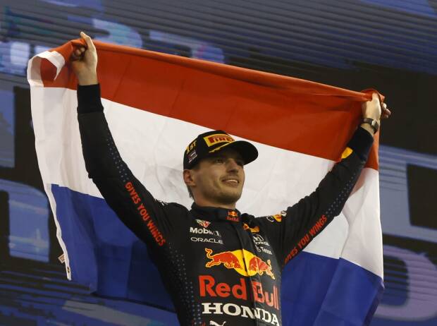 Max Verstappen feiert auf dem Podium nach dem Formel-1-Finale 2021 in Abu Dhabi mit der Flagge der Niederlande den Gewinn der Weltmeisterschaft