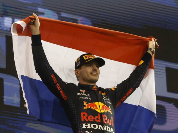 Max Verstappen feiert auf dem Podium nach dem Formel-1-Finale 2021 in Abu Dhabi mit der Flagge der Niederlande den Gewinn der Weltmeisterschaft Max Verstappen feiert auf dem Podium nach dem Formel-1-Finale 2021 in Abu Dhabi mit der Flagge der Niederlande den Gewinn der Weltmeisterschaft