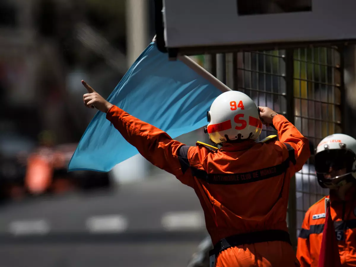 Streckenposten mit blauer Flagge Foto zur News: Piloten fordern: Überrundete sollen früher Platz machen