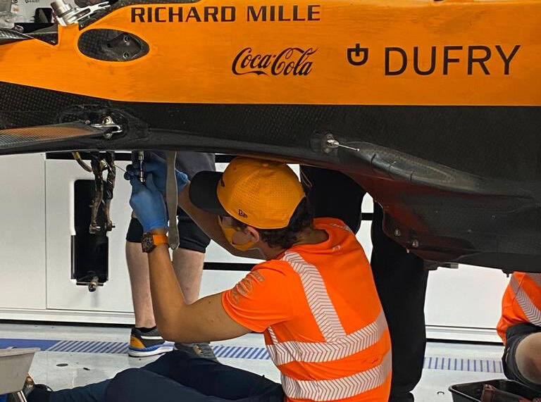 Foto zur News: Lando Norris hilft Mechanikern: "Will, dass es ihnen gut geht"