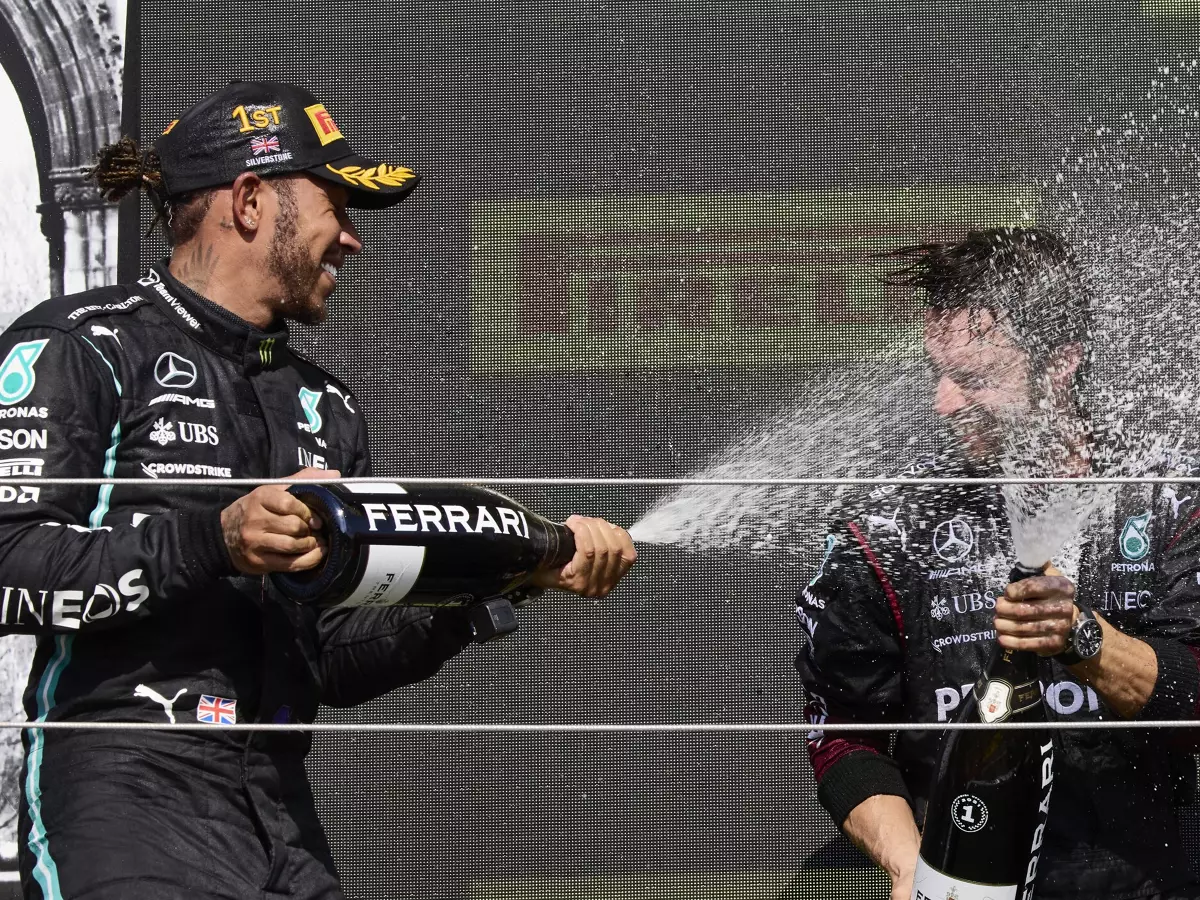 Formel 1 2021: Lewis Hamilton feiert seinen Sieg beim Grand Prix von Großbritannien 2021 in Silverstone mit Champagner der Marke Ferrari und einem Mercedes-Mitarbeiter Foto zur News: Jetzt spricht Max Verstappen: Hamilton und Mercedes "respektlos" in Silverstone