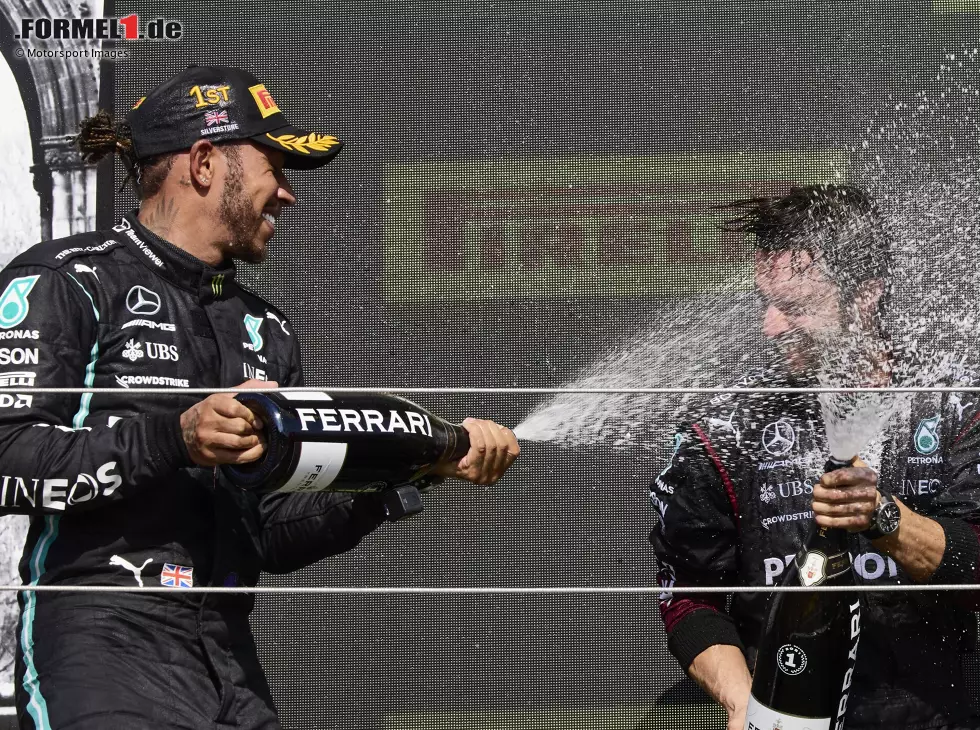 Formel 1 2021: Lewis Hamilton feiert seinen Sieg beim Grand Prix von Großbritannien 2021 in Silverstone mit Champagner der Marke Ferrari und einem Mercedes-Mitarbeiter Foto zur News: Formel 1 2021: Lewis Hamilton feiert seinen Sieg beim Grand Prix von Großbritannien 2021 in Silverstone mit Champagner der Marke Ferrari und einem Mercedes-Mitarbeiter