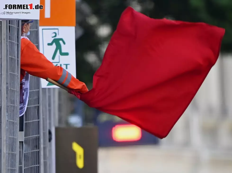 Ein Sportwart der Formel 1 schwenkt eine rote Flagge und signalisiert damit einen Abbruch der Einheit Foto zur News: Ein Sportwart der Formel 1 schwenkt eine rote Flagge und signalisiert damit einen Abbruch der Einheit