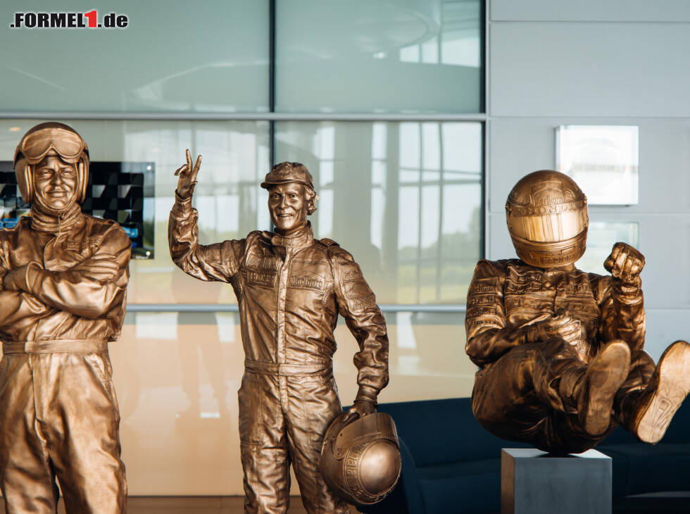 Foto zur News: Bruce McLaren, Niki Lauda, Ayrton Senna als Bornzestatuen in der McLaren-Fabrik in Woking